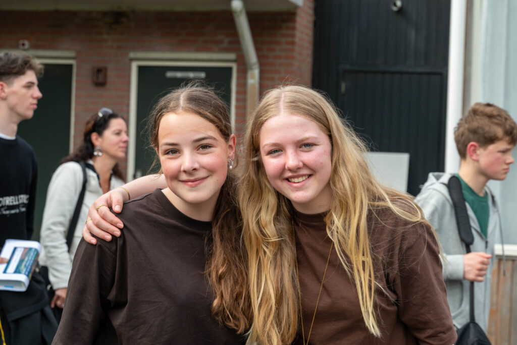 Twee tieners met de arm om elkaar heen tijdens Noorderwind