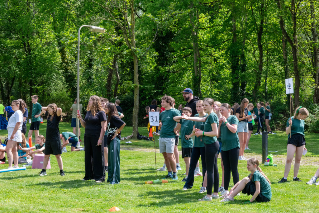 Tieners kijken en juichen tijdens een buitenspel bij Noorderwind